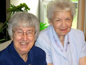 Sisters Jean Marie Hauck and Joan Wagner seated together and smiling