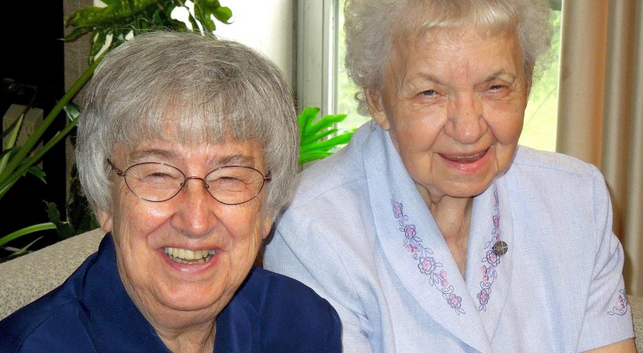 Sisters Jean Marie Hauck and Joan Wagner seated together and smiling