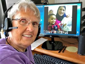 Sr. Pevas is shown at her computer, video conferencing with students.