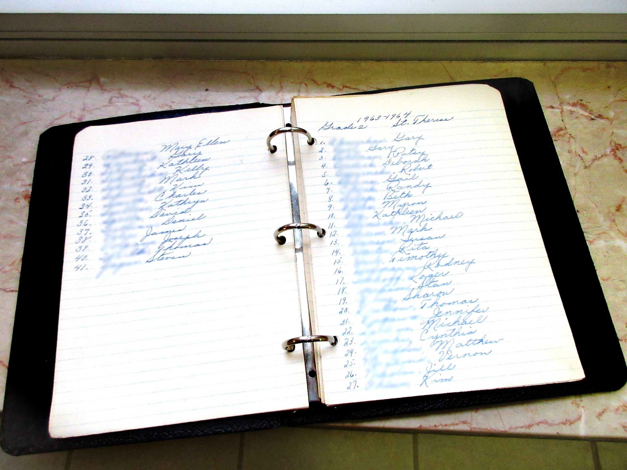 Pages from Sister Mary Jo's notebook in which she kept the names of each student throughout the years so she could continue to pray for them. Shown are from her 1963-1964 Second grade classroom.