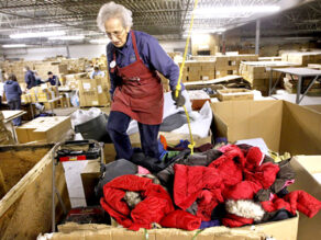 Sister Dora Zapf stomps down a box full of new jackets from Land's End that will be shipped to to a mission in Peru