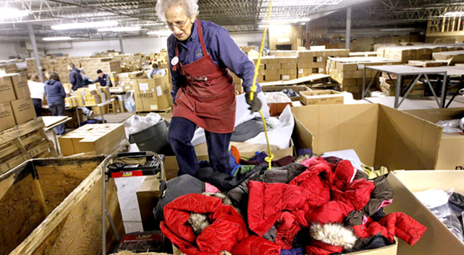 Sister Dora Zapf stomps down a box full of new jackets from Land's End that will be shipped to to a mission in Peru