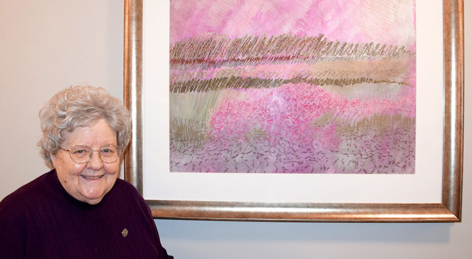 Sister Carla smiling with one of her original artworks.