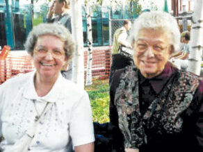 Sister Mary Louise Herrmann and a friend sitting outside and smiling