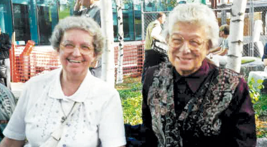 Sister Mary Louise Herrmann and a friend sitting outside and smiling